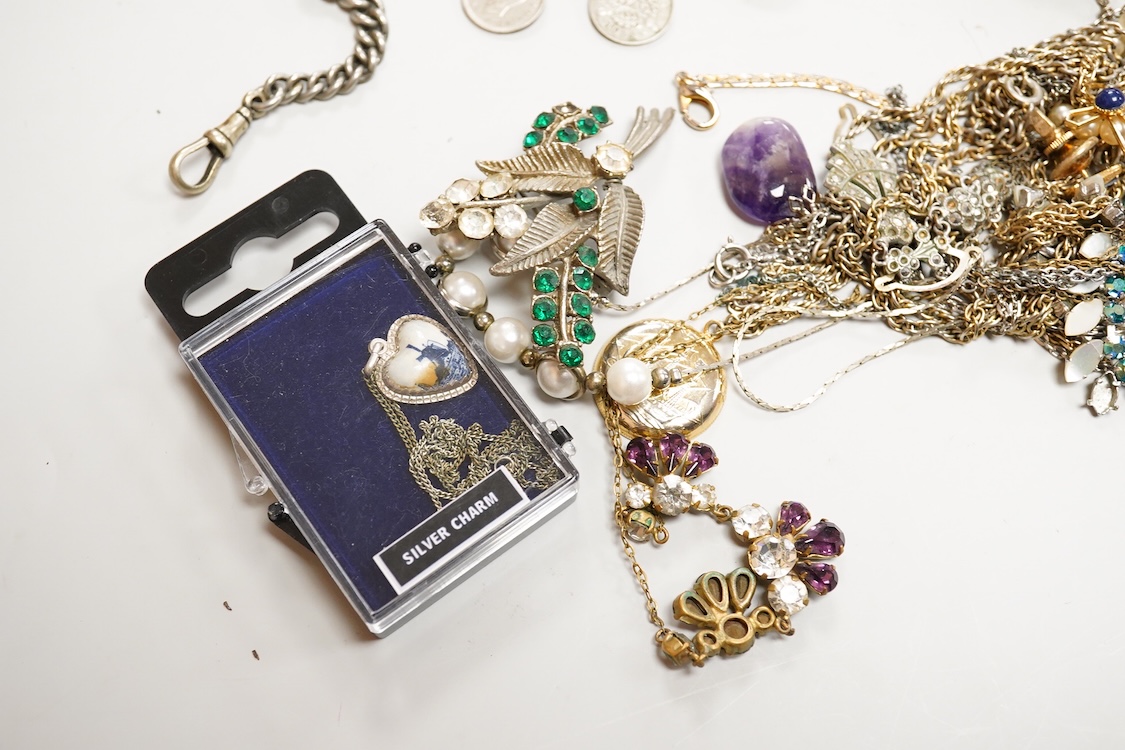 A collection of silver and costume jewellery, including a silver locket, St Christopher ingot pendant and watch chain, and a selection of costume jewels
